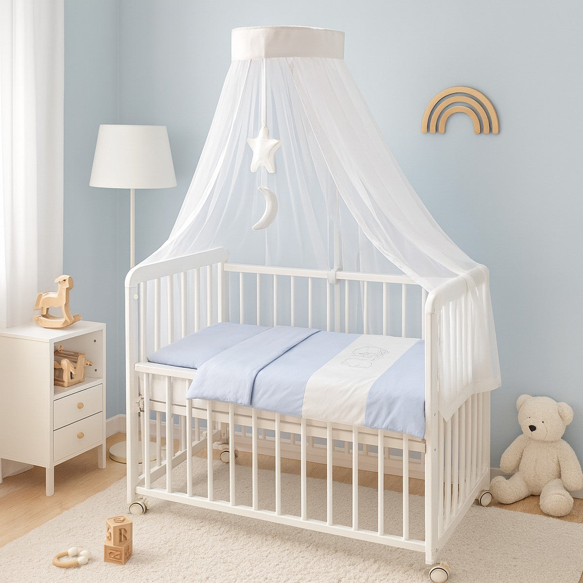 Weißes Beistellbett mit blauer Bettwäsche und Himmel im Babyzimmer