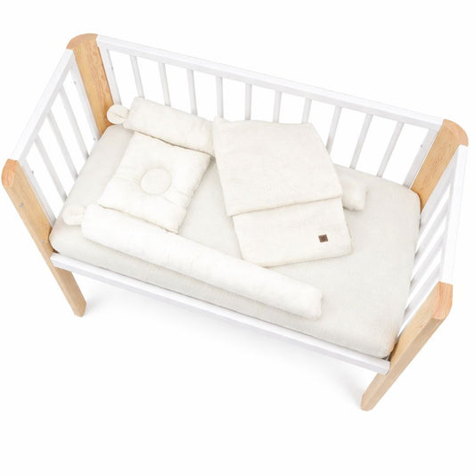 Babybett in Weiß-Natur mit cremefarbener Babybettwäsche, Draufsicht, Matratze mit Kissen, Decke und Nestchen