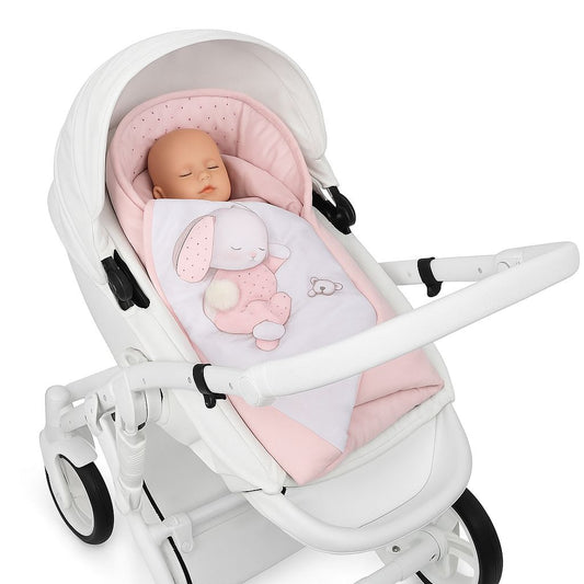 Babypuppe liegt in rosa Einschlagdecke mit Hasenmotiv in weißem Kinderwagen auf weißem Hintergrund