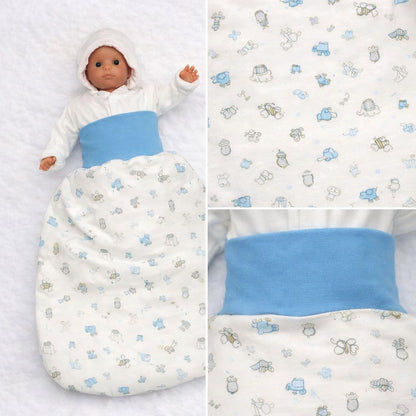 Detailaufnahme des Baumwollstoffs eines Babyschlafsacks mit Tiermotiven in Hellblau und Grau auf cremefarbenem Hintergrund