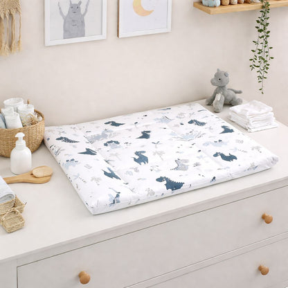 Flache Baby Wickelauflage 75 × 75 cm mit Dinosaurier-Motiven in Blau und Grau, aus Baumwolle, liegend auf weißer Wickelkommode im Kinderzimmer