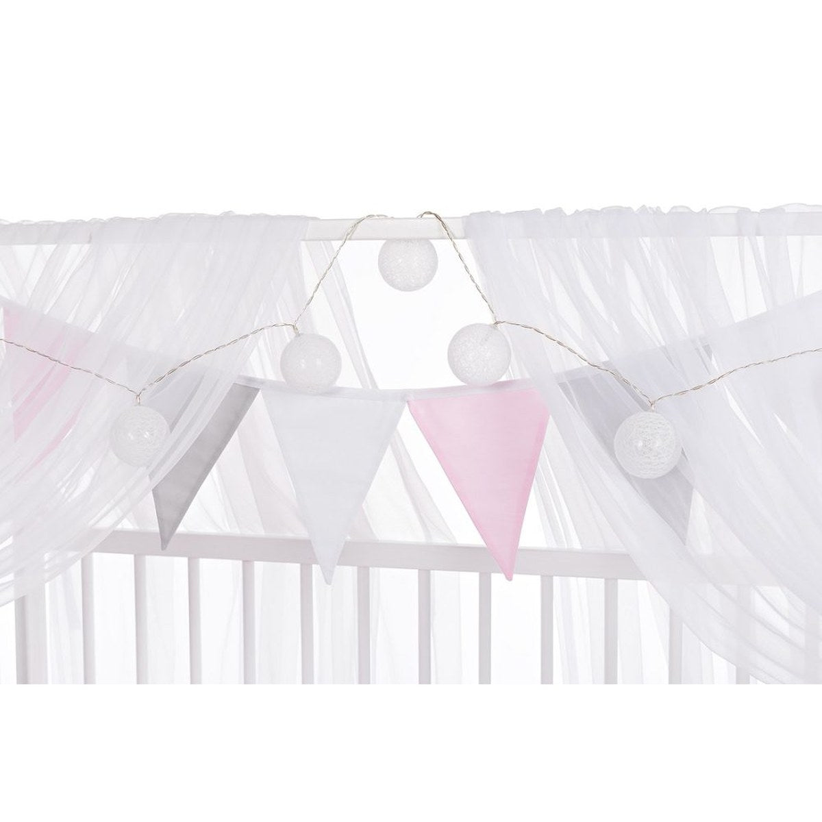 Babybett mit Baldachin und Stoffgirlande im Mädchenzimmer