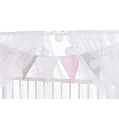 Babybett mit Baldachin und Stoffgirlande im Mädchenzimmer