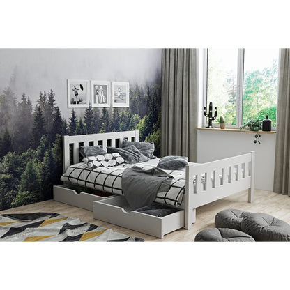 Weißes Massivholz-Kinderbett 200×90 cm mit zwei ausziehbaren Schubladen, präsentiert in einem modernen Zimmer mit Waldtapete