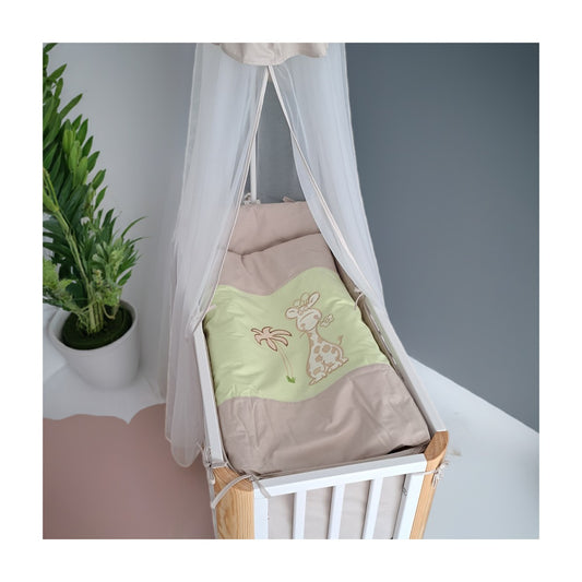 Babybett mit grün-beiger Bettwäsche und Giraffenmotiv