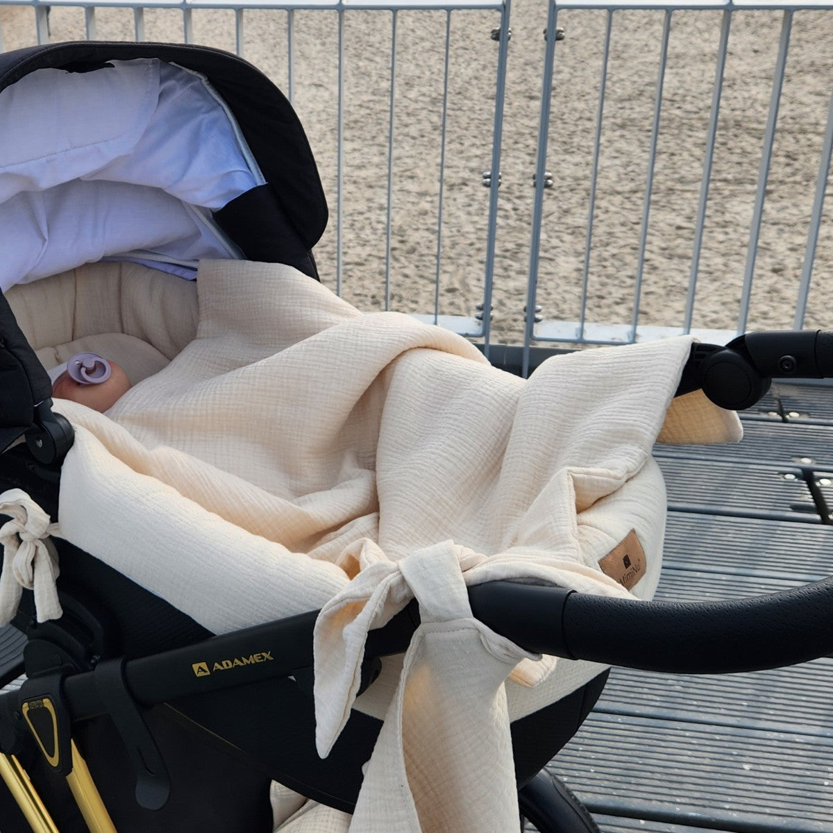 Baby im Kinderwagen mit beigem Musselin Set aus Baumwolle im Freien – gemütlich und atmungsaktiv